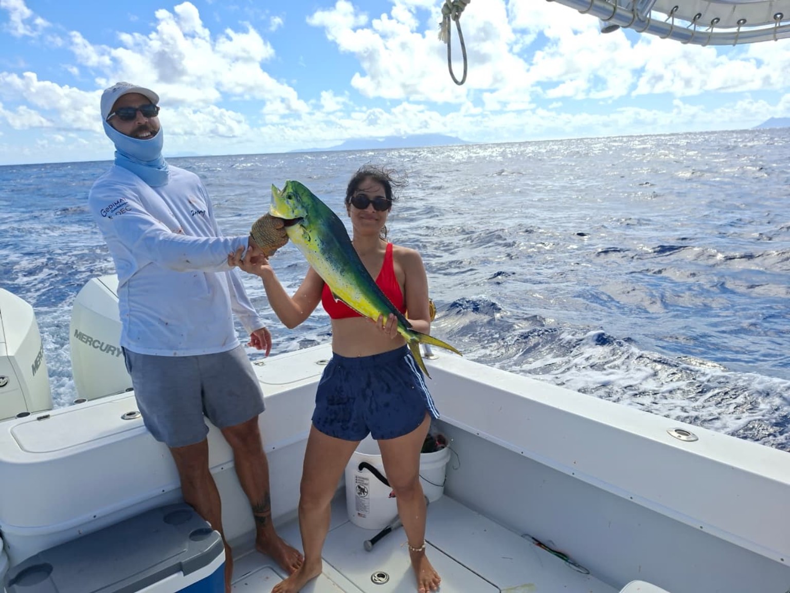 Guests with a mahi-mahi aboard Melicious
